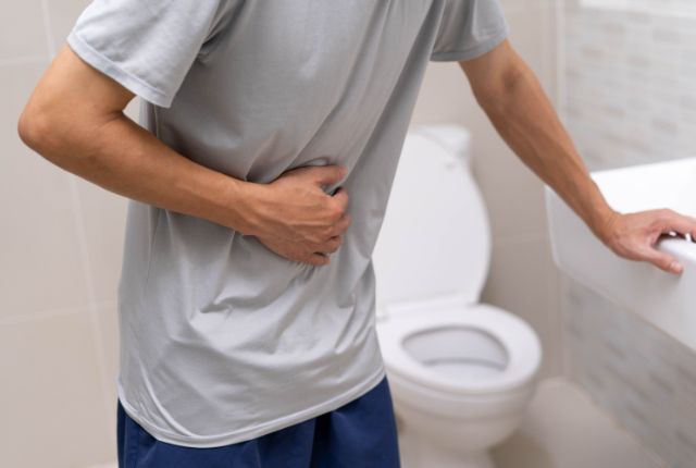 トイレで辛そうにしている男性
