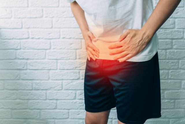 腹部を手で押さえる男性